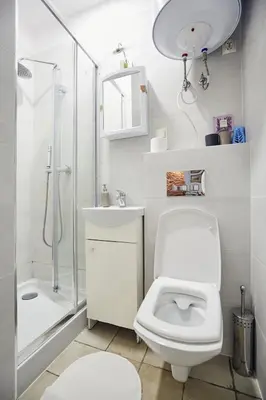 a white bathroom with a toilet and a shower at 29 Avenue Apartments in Kraków