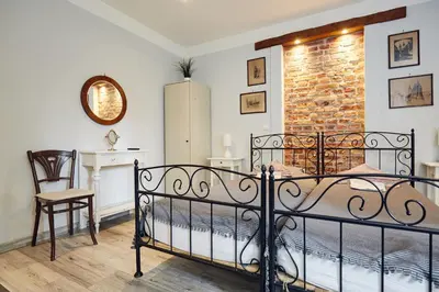 a bedroom with a bed and a brick wall at 29 Avenue Apartments in Kraków