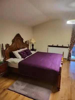 a bedroom with a large bed with a purple blanket at Apartament Kleopatra in Limanowa
