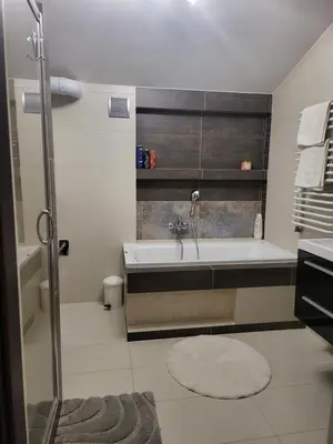 a bathroom with a bath tub and a sink at Apartament Kleopatra in Limanowa