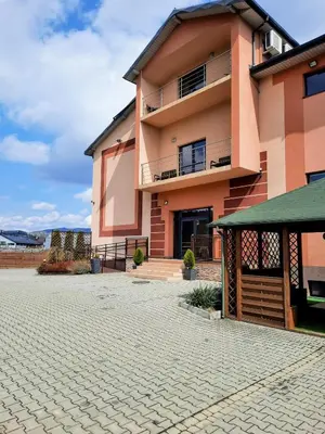 a large pink building with a brick driveway at Apartament Kleopatra in Limanowa