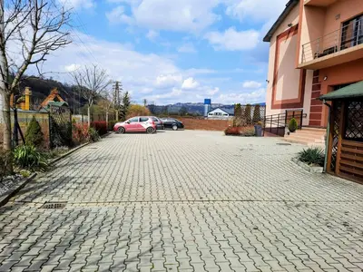 a car parked in a driveway next to a house at Apartament Kleopatra in Limanowa