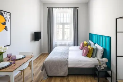 a bedroom with a bed with colorful pillows on it at Horizon Park Aparthotel in Kraków
