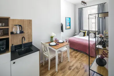 a small kitchen with a table and a bed in a room at Horizon Park Aparthotel in Kraków