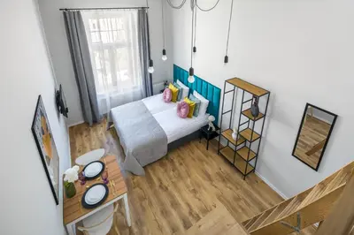 a small bedroom with a bed and a table at Horizon Park Aparthotel in Kraków