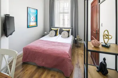 a bedroom with a large bed and a television at Horizon Park Aparthotel in Kraków