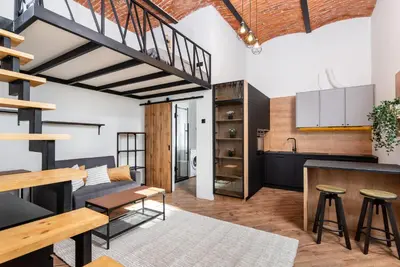 a kitchen and living room with a loft conversion at Horizon Park Aparthotel in Kraków