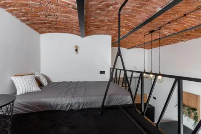 a bedroom with a bed in a brick wall at Horizon Park Aparthotel in Kraków