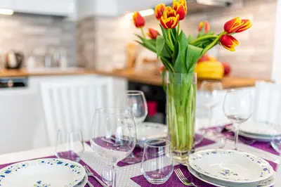 a table with wine glasses and a vase of flowers at Bella Casa Premium Apartment - 30 Pszczelna in Kraków