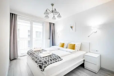 a white bedroom with a bed and a window at Bella Casa Premium Apartment - 30 Pszczelna in Kraków