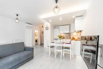 a living room and kitchen with a couch and a table at Bella Casa Premium Apartment - 30 Pszczelna in Kraków