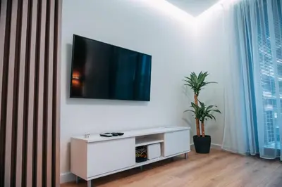 a living room with a tv on a white wall at Vistula Terraces Apartment in Kraków