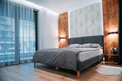 a bedroom with a bed and large windows at Vistula Terraces Apartment in Kraków