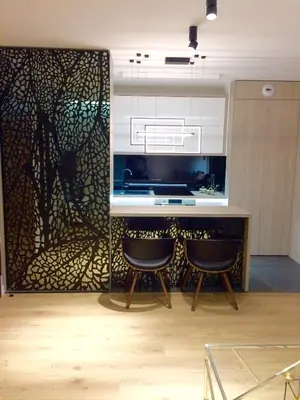 a kitchen with a counter with two bar stools at Vistula Terraces Apartment in Kraków