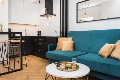 a living room with a blue couch and a table at City of the Kings-Bacalar Apartment in Kraków