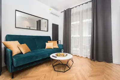 a living room with a green couch and a table at City of the Kings-Bacalar Apartment in Kraków