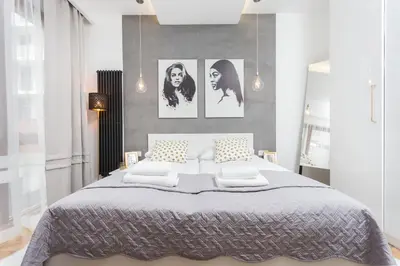 a bedroom with a large bed with four pictures on the wall at City of the Kings-Bacalar Apartment in Kraków