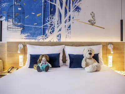 a hotel room with a large bed and a desk at ibis Styles Kraków East in Kraków