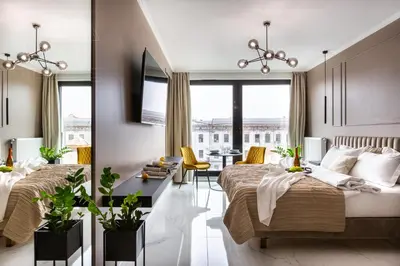 a bedroom with two beds and a living room at Fragola Apartments Rajska 3 - modern studios, park in Kraków