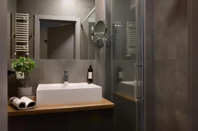 a bathroom with a white sink and a shower at Fragola Apartments Rajska 3 - modern studios, park in Kraków