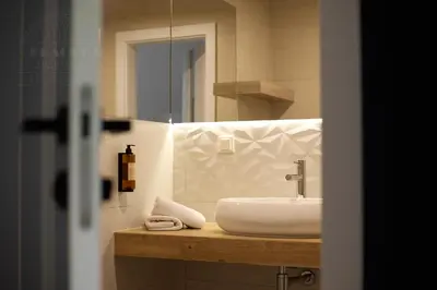 a bathroom with a sink and a mirror at Fragola Apartments Rajska 3 - modern studios, park in Kraków