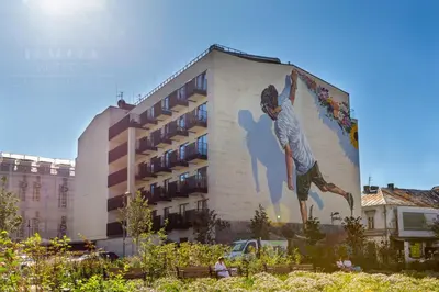 a mural of a man on the side of a building at Fragola Apartments Rajska 3 - modern studios, park in Kraków