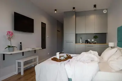 a bedroom with a bed with a teddy bear on it at Fragola Apartments Rajska 3 - modern studios, park in Kraków