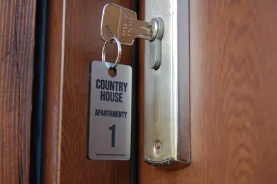 a security house tag hanging on a door at Country House - apartamenty blisko Energylandii in Spytkowice