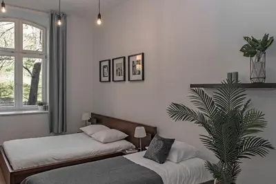 a bedroom with two beds and a palm tree at 3D Wawel Apartament in Kraków