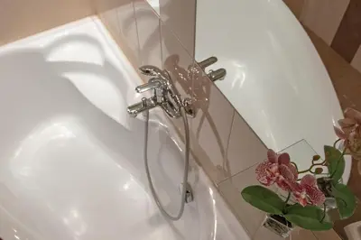a bathroom sink with a faucet next to a shower at 3D Wawel Apartament in Kraków