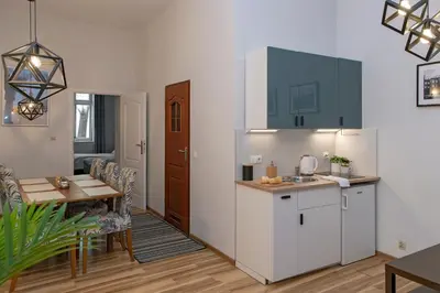 a kitchen and dining room with a table and a counter at 3D Wawel Apartament in Kraków