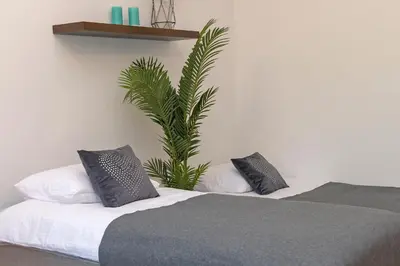 a bedroom with a bed and a plant on the wall at 3D Wawel Apartament in Kraków