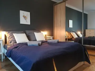 a bedroom with a large bed with a blue blanket at Szeroka View Apartment in Kraków