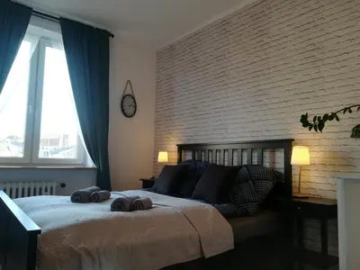 a bedroom with a large bed with two towels on it at Szeroka View Apartment in Kraków