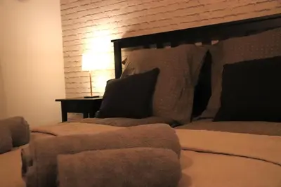 a bedroom with two beds and a table with a lamp at Szeroka View Apartment in Kraków