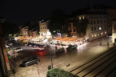 a city at night with cars parked in a parking lot at Szeroka View Apartment in Kraków