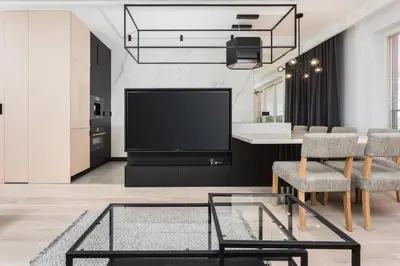 a living room with a tv and a table and chairs at City of the Kings-Bijou Apartment in Kraków