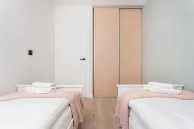 a room with two beds with pink towels on them at City of the Kings-Bijou Apartment in Kraków