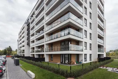 an apartment building with balconies and a parking lot at City of the Kings-Bijou Apartment in Kraków