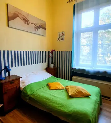 a bedroom with a bed with green sheets and a window at The apartment in strict city center. Self check-in in Kraków
