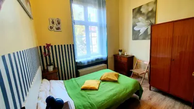 a small bedroom with a green bed and a window at The apartment in strict city center. Self check-in in Kraków