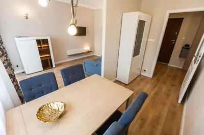 a dining room with a table and blue chairs at Vintage Krasińskiego 7 Apartments in Kraków