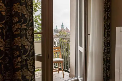 a room with a balcony with a chair and a window at Vintage Krasińskiego 7 Apartments in Kraków