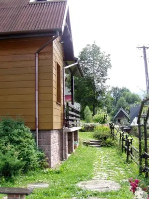 a house with a fence next to a yard at domek w centrum w Zawoi in Zawoja