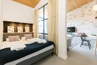 a bedroom with a king sized bed and a kitchen at Central balcony apartment - Window on Cracow in Kraków