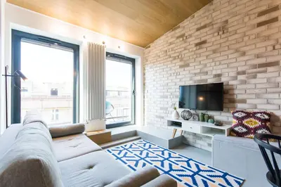 a living room with a brick wall at Central balcony apartment - Window on Cracow in Kraków