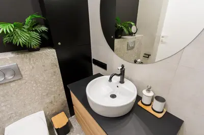 a bathroom with a sink and a mirror at Central balcony apartment - Window on Cracow in Kraków