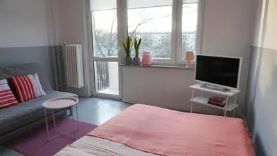 a small living room with a couch and a television at Lovely Madly Apartment in Kraków