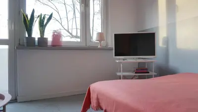 a bedroom with a bed and a flat screen tv at Lovely Madly Apartment in Kraków