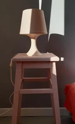 a table with a lamp on top of a stool at Lovely Madly Apartment in Kraków